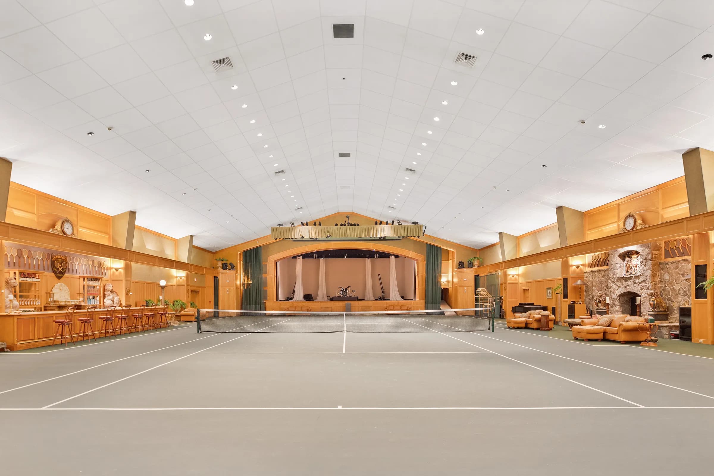 The indoor tennis court from the baseline, its professional stage beyond the net