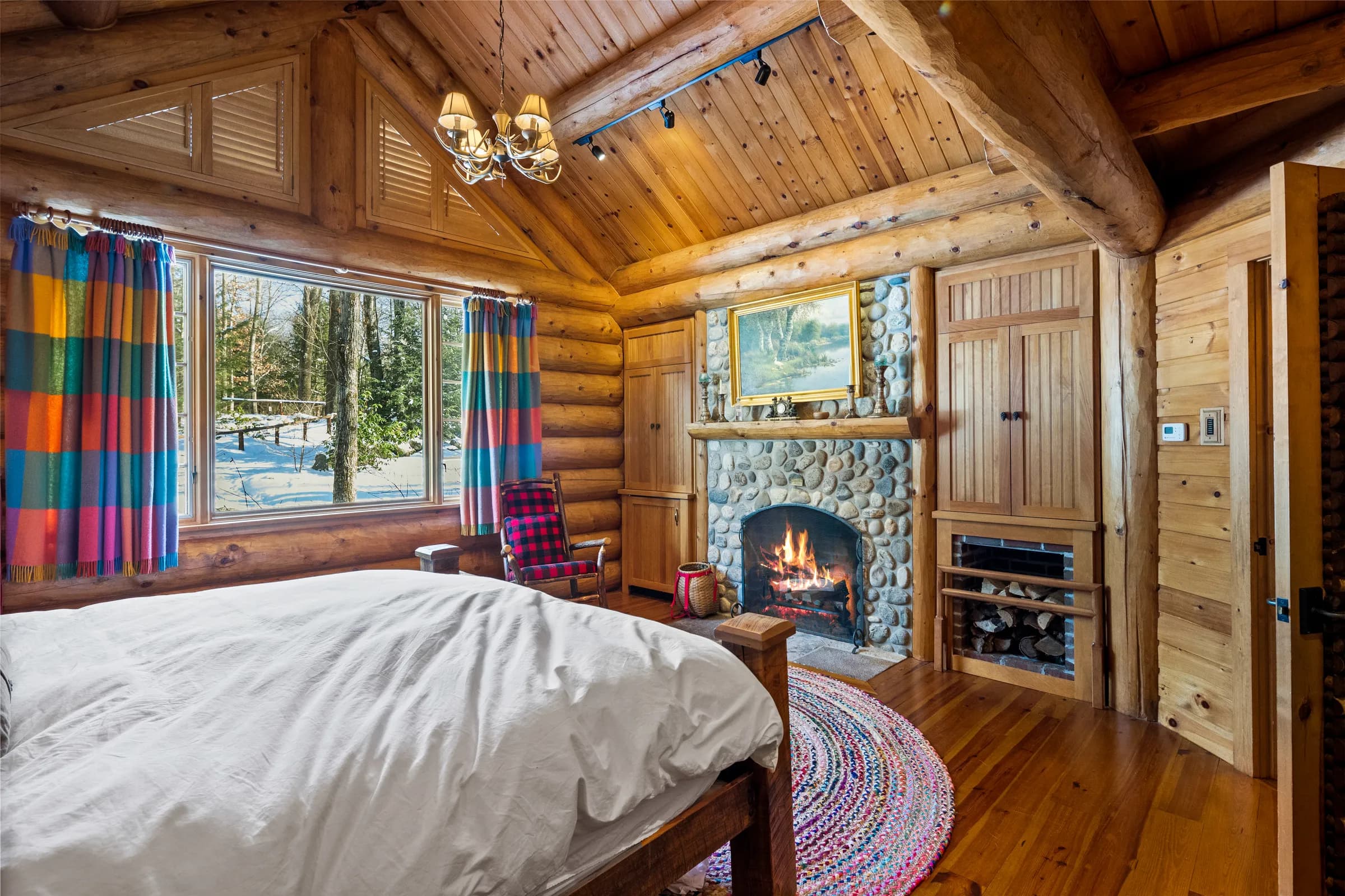 A Lodge bedroom with its own fireplace, dressed in plaid