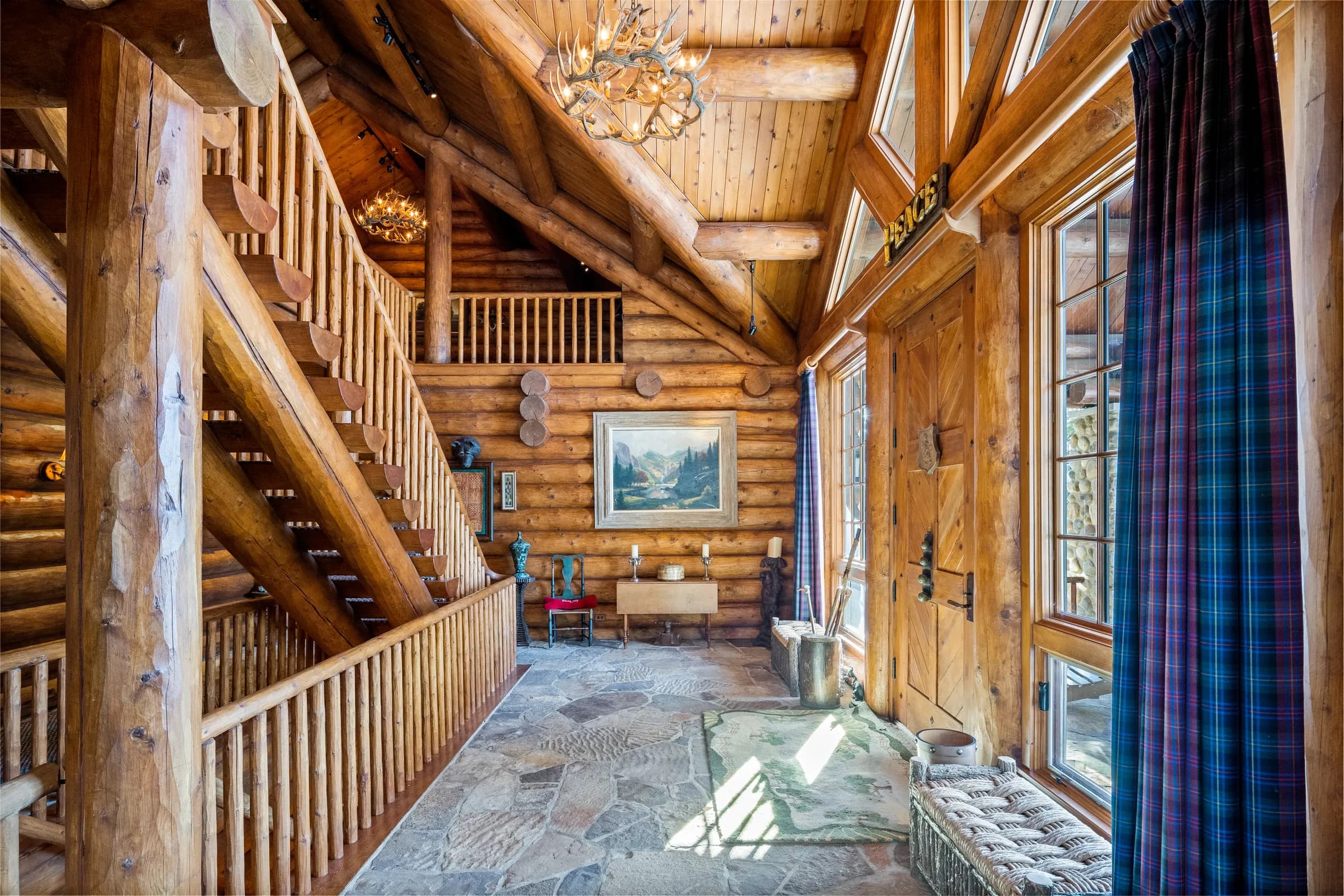The stone-floored entry hall framed in whole-log walls