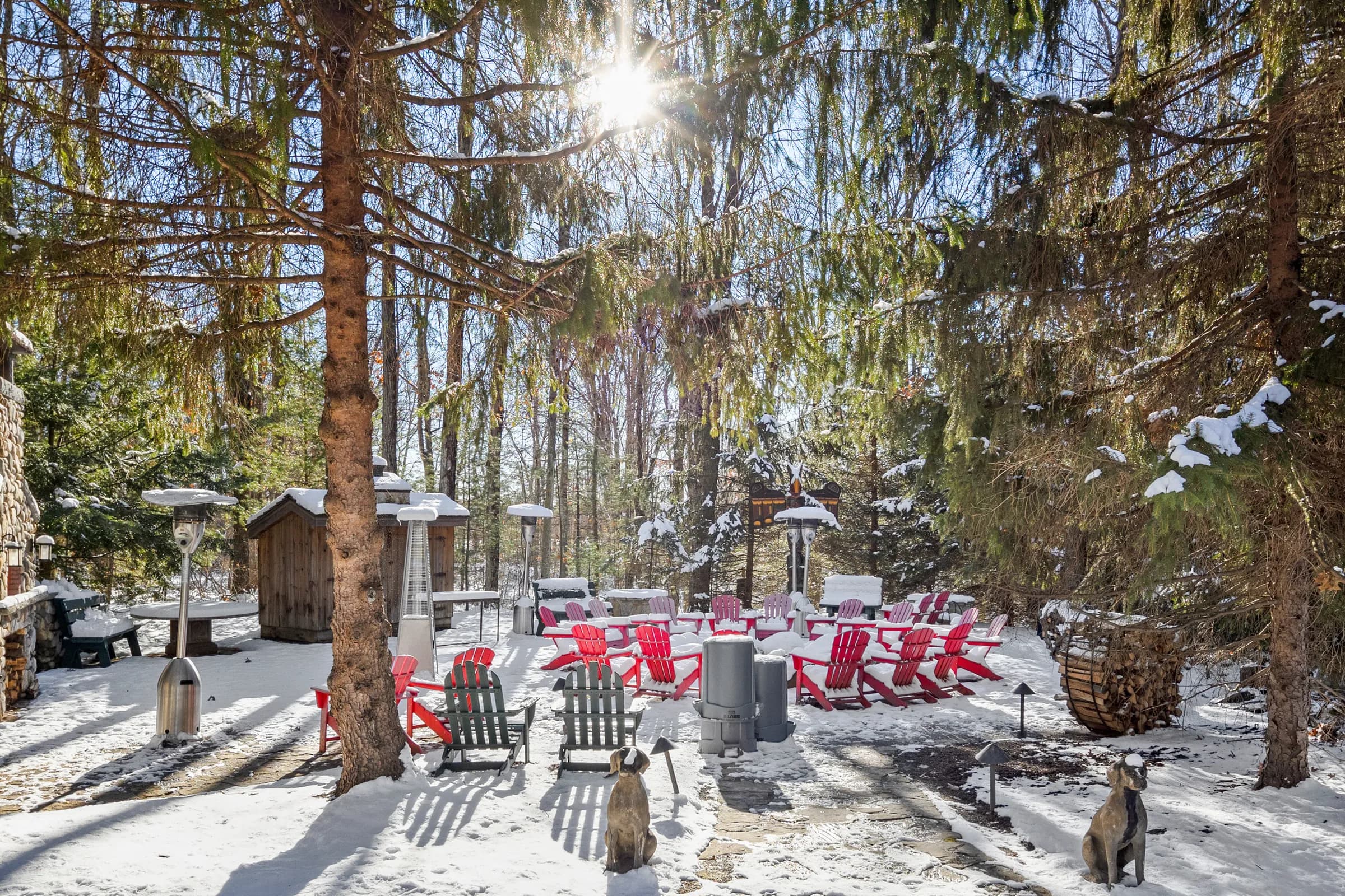 The firepit ringed by red Adirondack chairs in the snow