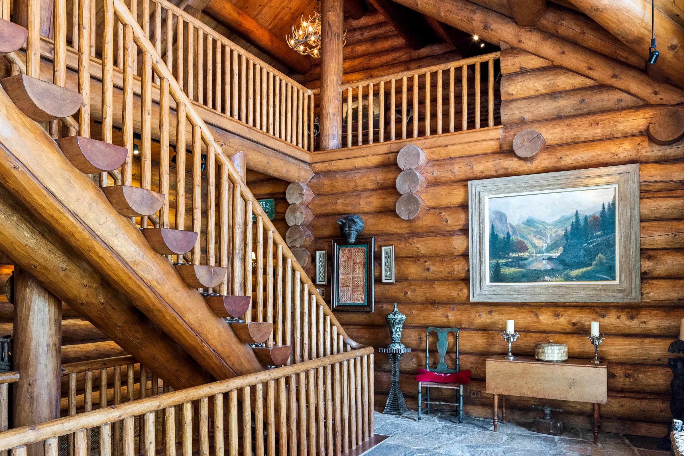 The grand log staircase climbing past the gallery rail