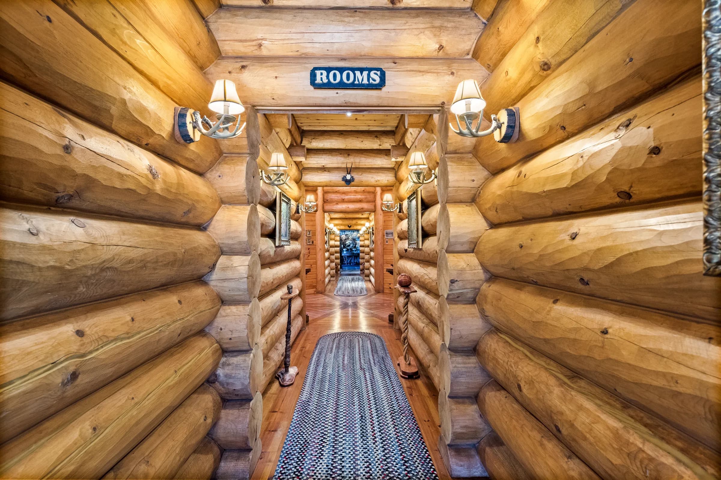 The guest-wing corridor beneath its vintage ROOMS sign