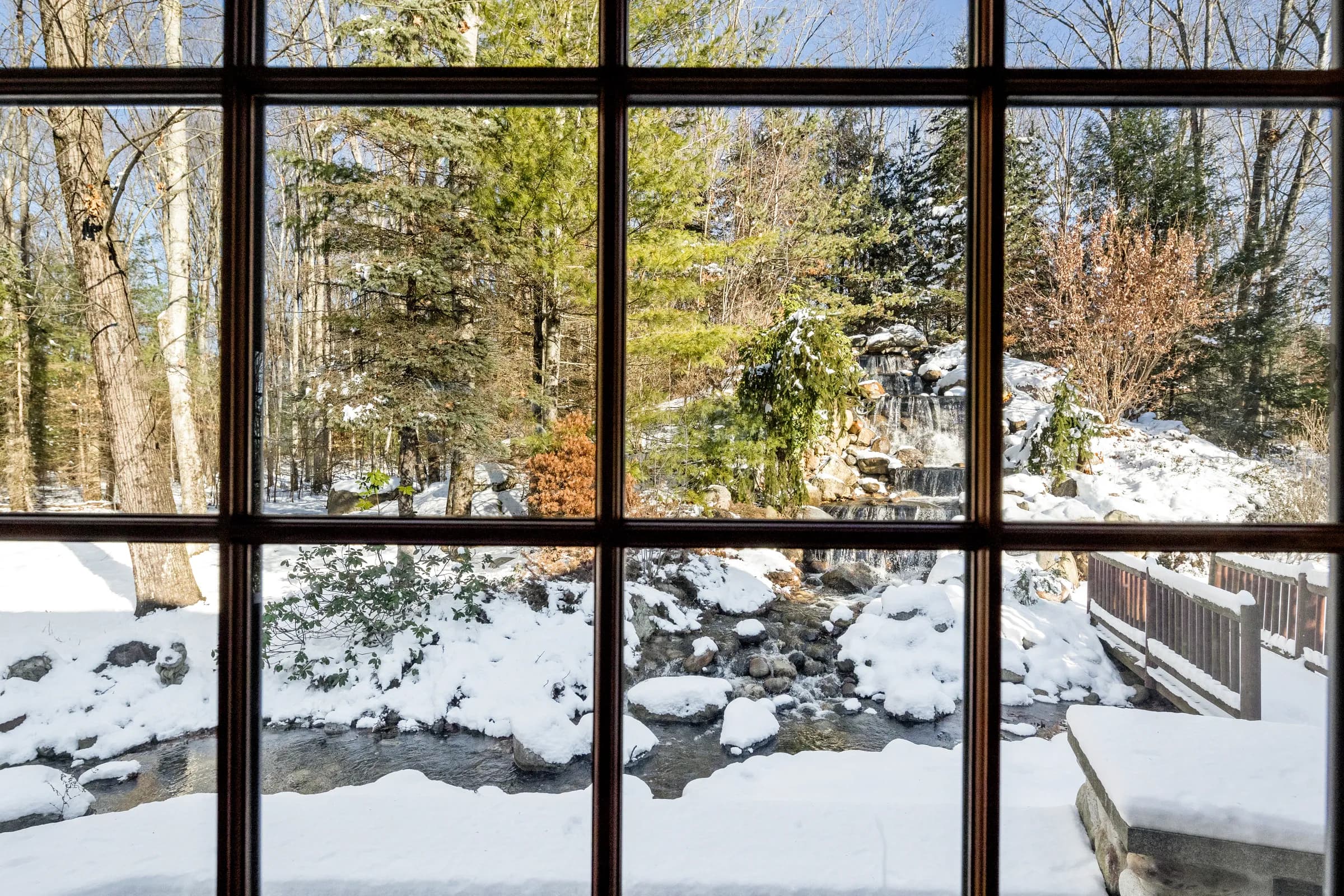 The snowy stream framed pane by pane in The Lodge's window grid