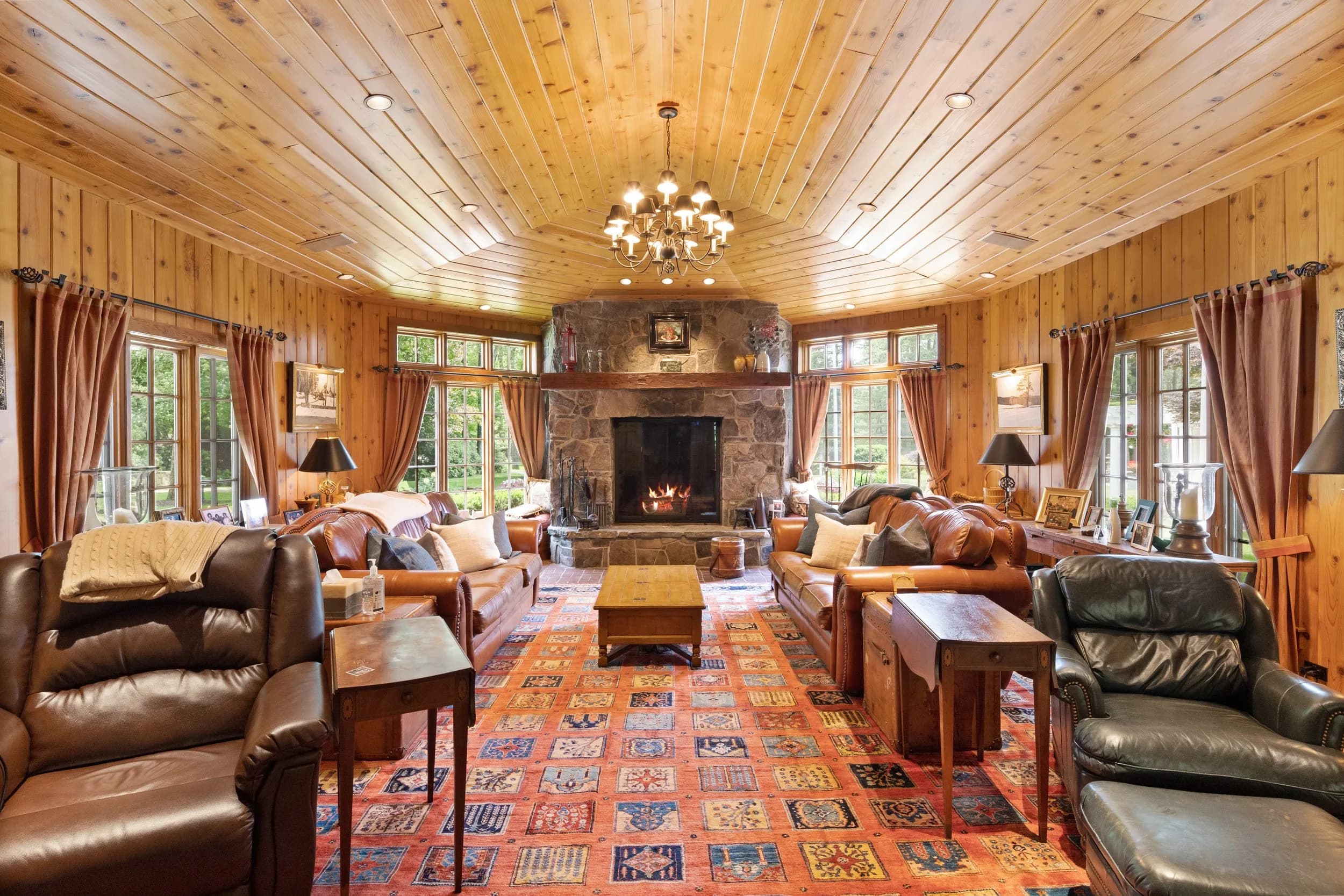 The knotty-pine den and its stone fireplace