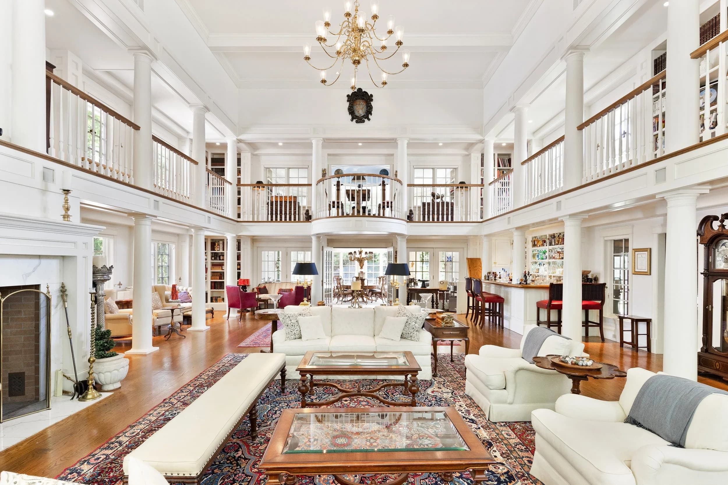 The three-story great room beneath its crest medallion and twin library balconies