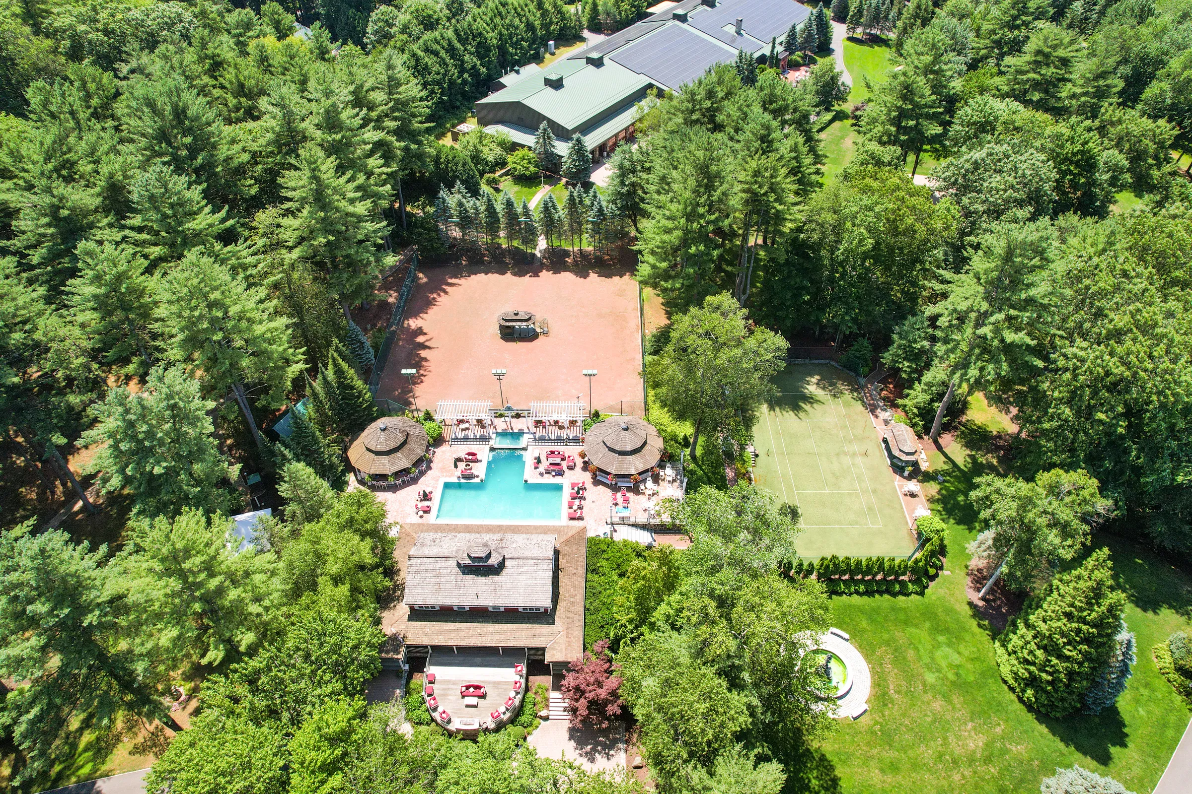 Drone view of the estate pool, twin gazebos, and tennis courts at Juggler Meadow, set for a private group celebration in Leverett, Massachusetts